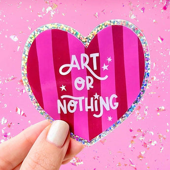 Heart-shaped sticker with 'Art or Nothing' text on a pink background